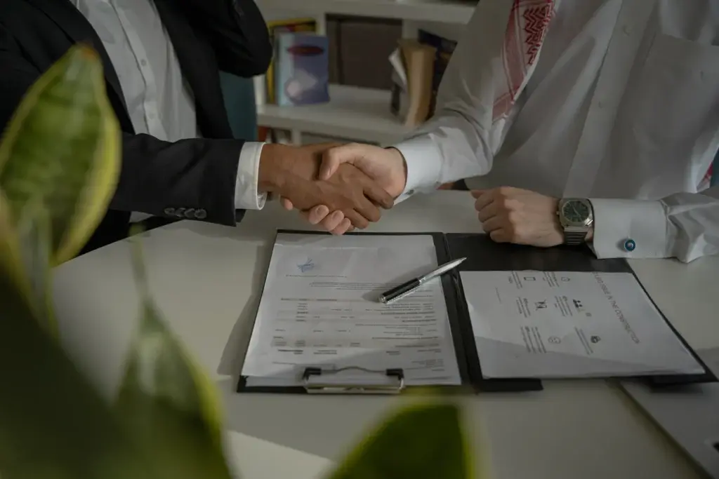 Poignée de mains au-dessus d'un contrat d'assurance protection juridique